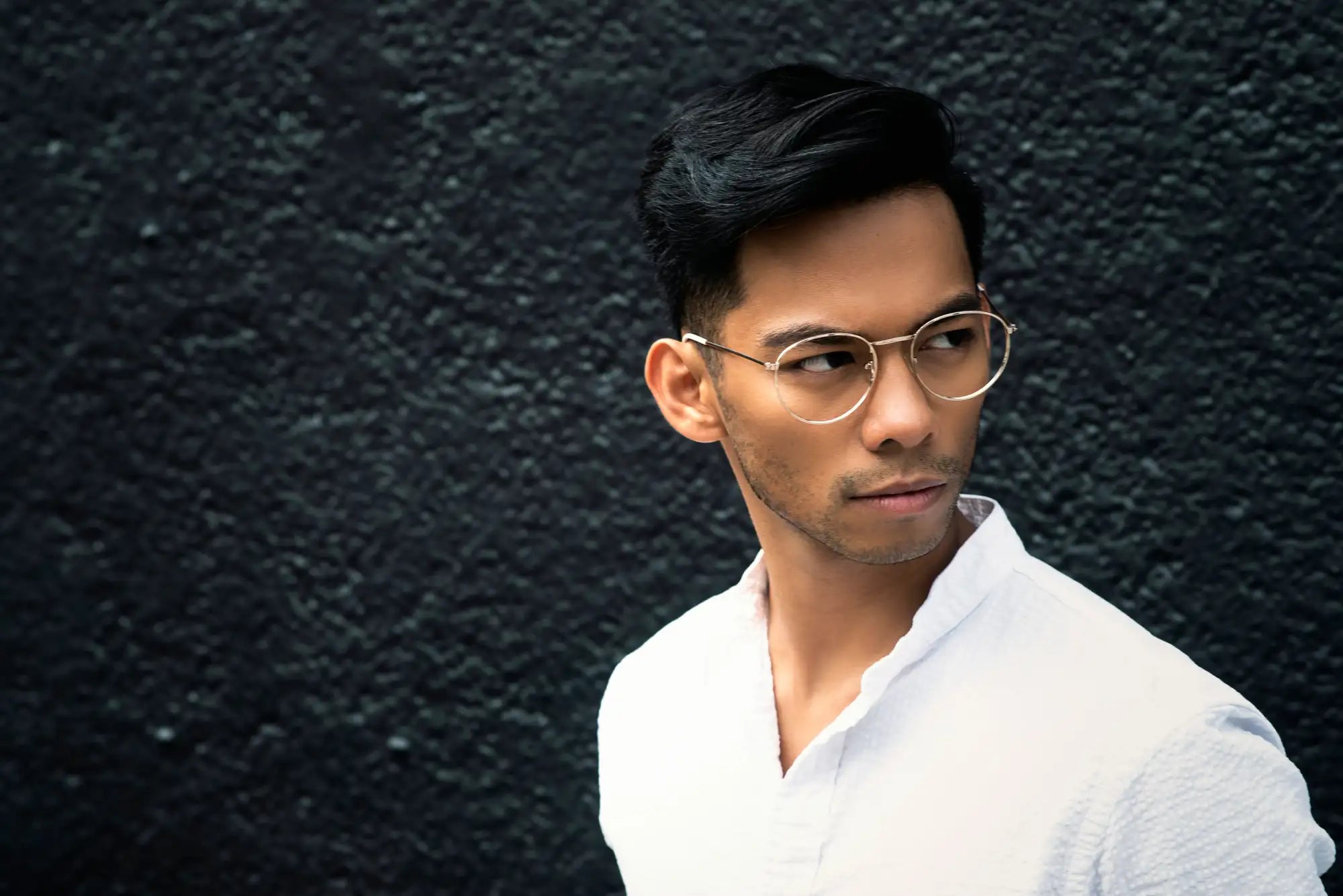 A pair of thin, gold-toned round-framed glasses with a minimalist design.